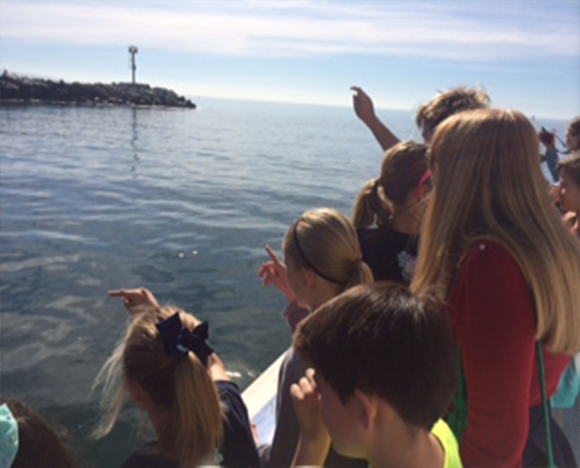 A group of children look out at the Pacific Ocean from a boat while participating in the Marine Education program.